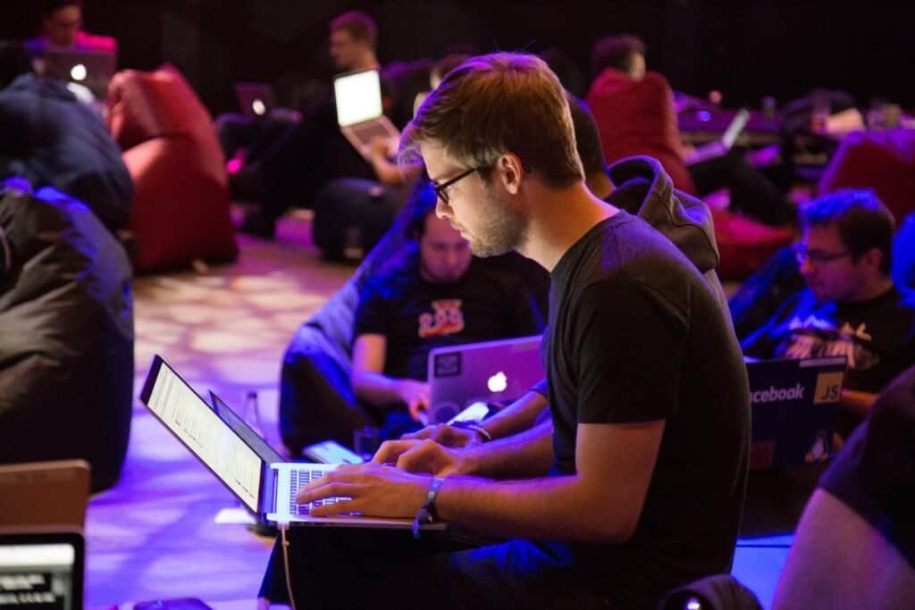 man using laptop in front of brown chair in hacking competiton 